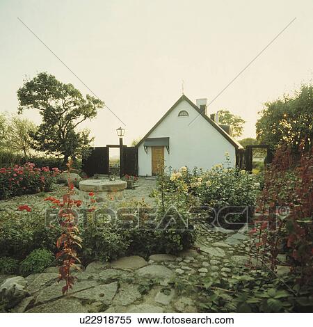 Stock Photography - Paving in garden of small house in summer. Fotosearch