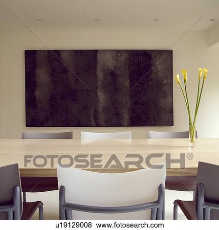 Philippe Starck 'Cheap Chic' chairs and Boffi Monforte maple-topped table in architectural diningroom with large black painting on wall View Large Photo Image Stock Photo - Philippe Starck 'Cheap Chic' chairs and Boffi Monforte maple-topped table in architectural diningroom with large black painting on wall. Fotosearch