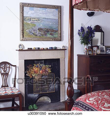 Picture above stone fireplace with firescreen in small traditional bedroom View Large Photo Image Stock Image - Picture above stone fireplace with firescreen in small traditional bedroom. Fotosearch