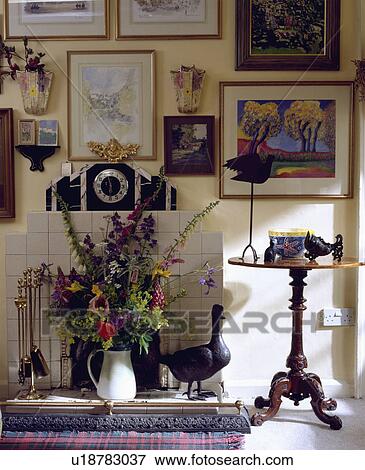 Pictures above fireplace with fresh flower arrangement View Large Photo Image Stock Photo - Pictures above fireplace with fresh flower arrangement. Fotosearch