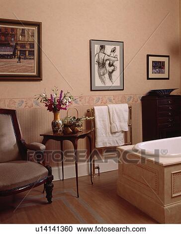Pictures above wallpaper border in peach bathroom with painted wooden flooring View Large Photo Image Stock Image - Pictures above wallpaper border in peach bathroom with painted wooden flooring. Fotosearch
