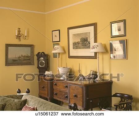 Pictures on wall above sideboard in yellow livingroom View Large Photo Image Stock Photo - Pictures on wall above sideboard in yellow livingroom. Fotosearch