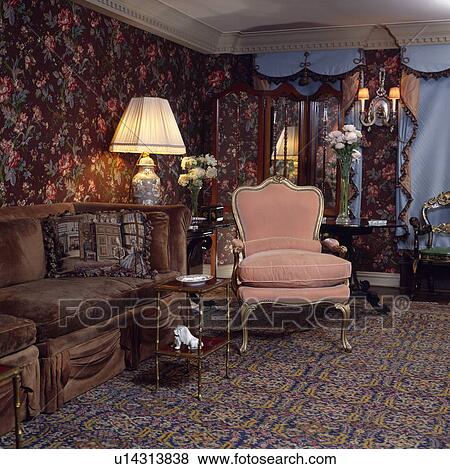 Pink armchair and lighted lamp in traditional living room View Large Photo Image Stock Photo - Pink armchair and lighted lamp in traditional living room. Fotosearch