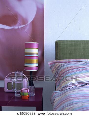 Pink Roberts radio and pink+yellow+white striped lamp on table beside bed with candystriped pillow and duvet View Large Photo Image Stock Photo - Pink Roberts radio and pink+yellow+white striped lamp on table beside bed with candystriped pillow and duvet. Fotosearch