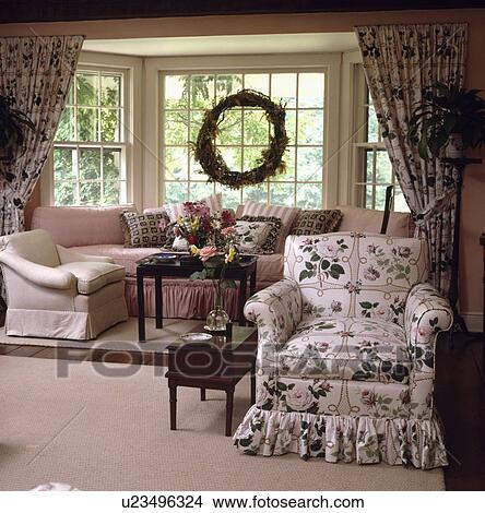 Pink+green floral loosecover on armchair in traditional country living room View Large Photo Image Picture - Pink+green floral loosecover on armchair in traditional country living room. Fotosearch