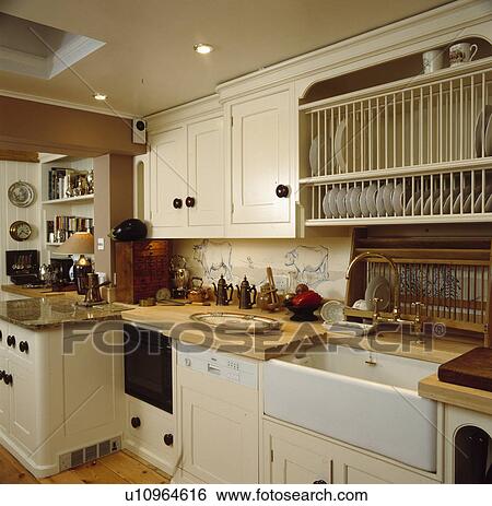 Plate rack above white ceramic sink and integral dishwasher in neutral kitchen View Large Photo Image Stock Photograph - Plate rack above white ceramic sink and integral dishwasher in neutral kitchen. Fotosearch