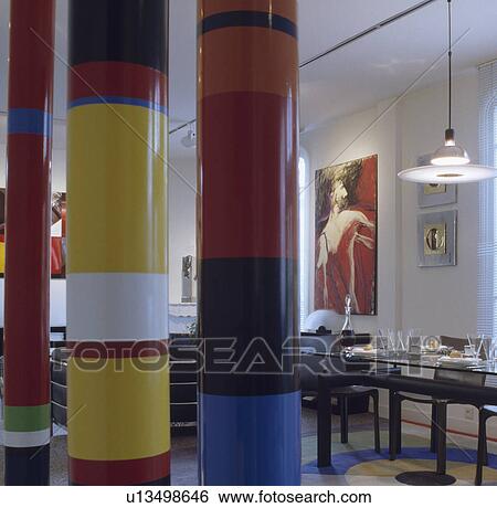 Primary coloured striped columns in modern dining room with pendant disc lights above table View Large Photo Image Stock Photograph - Primary coloured striped columns in modern dining room with pendant disc lights above table. Fotosearch