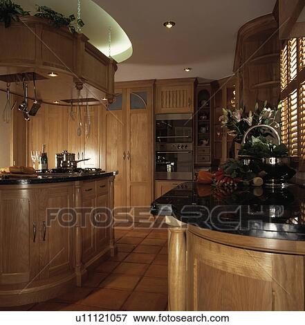 Recessed downlighting in light wood kitchen with black granite worktopsand island unit View Large Photo Image Stock Photo - Recessed downlighting in light wood kitchen with black granite worktopsand island unit. Fotosearch