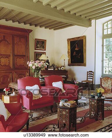 Red Armchairs In Traditional Living Room With Painted Cream Beamed