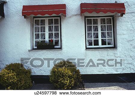 Red awnings over windows in whitewashed country cottage View Large Photo Image Stock Photo - Red awnings over windows in whitewashed country cottage. Fotosearch
