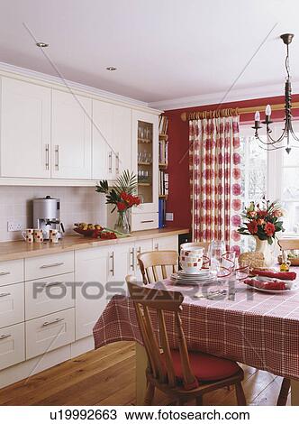 Red Checked Cloth On Table In Country Kitchen With Cream Units And