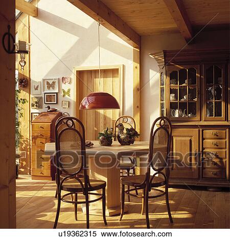 Red pendant lamp over wooden pedestal table and Bentwood Thonet chairs in dining room with wooden flooring View Large Photo Image Stock Photography - Red pendant lamp over wooden pedestal table and Bentwood Thonet chairs in dining room with wooden flooring. Fotosearch