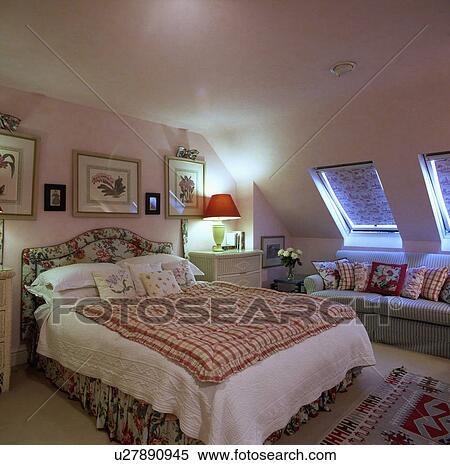 Red+white checked quilt with red quilt on bed with floral upholstered headboard in attic conversion bedroom View Large Photo Image Stock Photography - Red+white checked quilt with red quilt on bed with floral upholstered headboard in attic conversion bedroom. Fotosearch