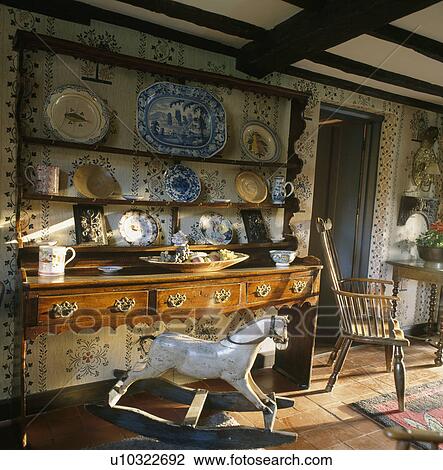 Rockinghorse in front of antique dresser and shelves in traditional diningroom with stencilled walls View Large Photo Image Stock Image - Rockinghorse in front of antique dresser and shelves in traditional diningroom with stencilled walls. Fotosearch