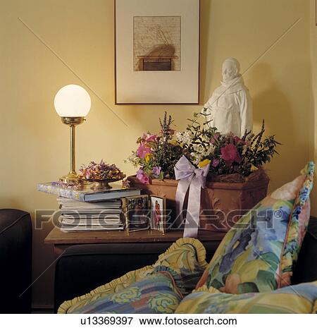 Side Table with Figurine, Flower Arrangement and Pile of Books. View Large Photo Image Stock Photo - Side Table with Figurine, Flower Arrangement and Pile of Books.. Fotosearch