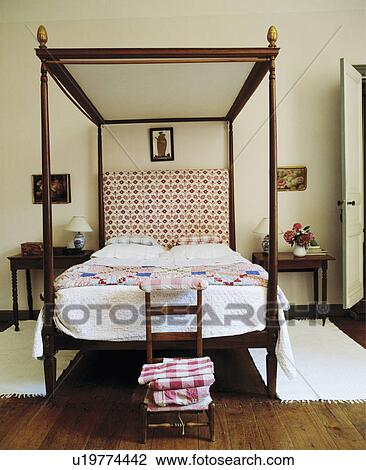 Stock Photo Of Simple Four Poster Bed With White Quilt And Patchwork Simple Four Poster Bed With White Quilt And Patchwork In Country Bedroom Rugs On Wooden Floor