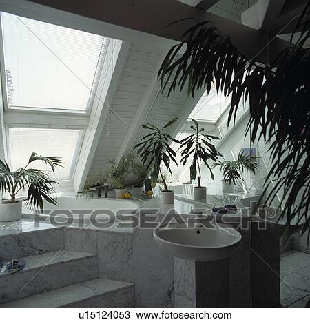 Small mirrored white bathroom with marble tiled steps leading to sunk bath in the eaves of a modern attic conversion View Large Photo Image Stock Image - Small mirrored white bathroom with marble tiled steps leading to sunk bath in the eaves of a modern attic conversion. Fotosearch