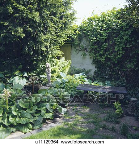Small statue on bench in walled garden in summer View Large Photo Image Picture - Small statue on bench in walled garden in summer. Fotosearch