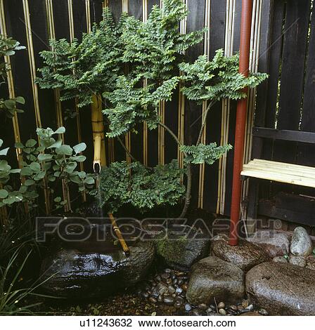 Small water feature in oriental-style town garden View Large Photo Image Stock Image - Small water feature in oriental-style town garden. Fotosearch