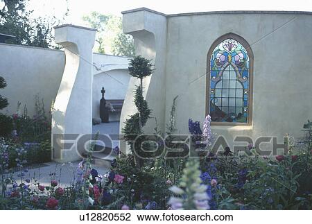Stock Image - Stained glass window in walled patio . Fotosearch
