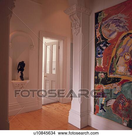 Picture - Statue in alcove and ornate corbel cornice in modern white hall with large abstract picture and wooden flooring. Fotosearch