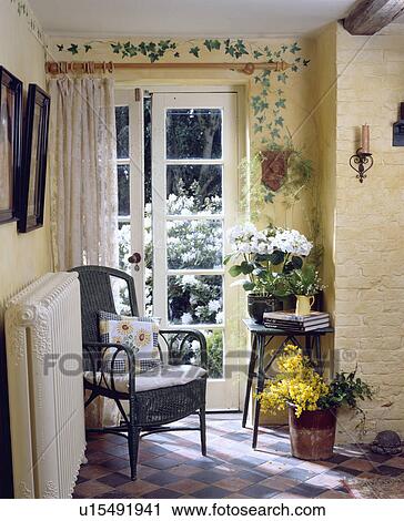 Stencilled pattern of ivy over French doors of small hall with flowering houseplants and black wicker chair View Large Photo Image Stock Image - Stencilled pattern of ivy over French doors of small hall with flowering houseplants and black wicker chair. Fotosearch