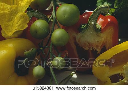 Stock Image - Still-life of green tomatoes and red pepper. Fotosearch