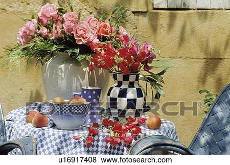 Stock Photo - Still-life of pink roses and red sweetpeas in floral arrangements. Fotosearch