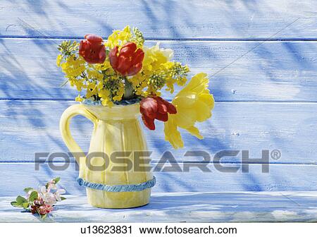 Stock Image - Still-Life of yellow and red tulips in yellow jug. Fotosearch