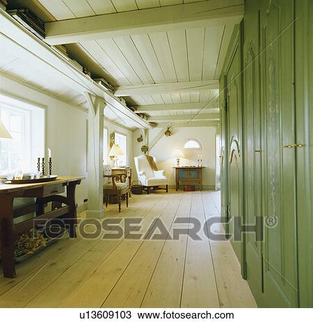 Stripped wooden floorboards and green wall cupboards in country hall living room with painted wooden ceiling View Large Photo Image Stock Image - Stripped wooden floorboards and green wall cupboards in country hall living room with painted wooden ceiling. Fotosearch