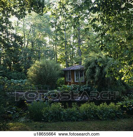 Summerhouse in beside stream in woodland garden View Large Photo Image Picture - Summerhouse in beside stream in woodland garden. Fotosearch