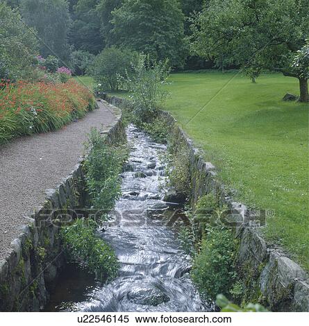 Sunken stream between stone banks in country garden View Large Photo Image Stock Photography - Sunken stream between stone banks in country garden. Fotosearch