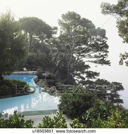 Stock Image - Swimming pool in Italian garden overlooking the sea. Fotosearch