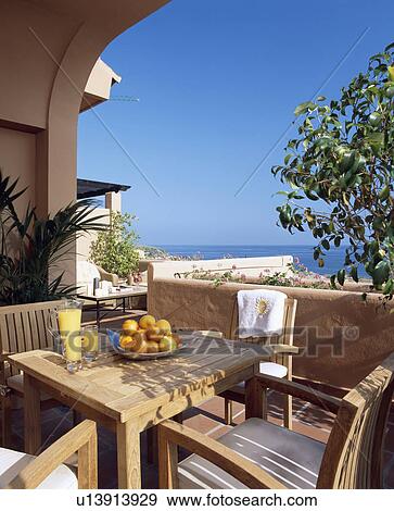 Stock Photo - Table on veranda of villa in Southern Spain with view of the sea. Fotosearch