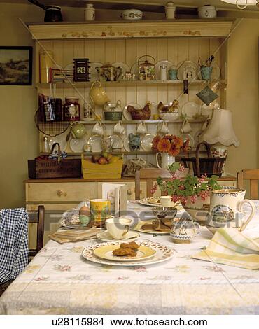 Picture - Table set for breakfast in country dining room with large pine dresser. Fotosearch