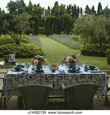 Table with blue cloth in country garden in summer with grass path and herbaceous borders View Large Photo Image Stock Photo - Table with blue cloth in country garden in summer with grass path and herbaceous borders. Fotosearch