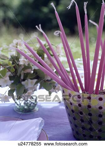 Tall pink candles in spotted pot on table View Large Photo Image Stock Photography - Tall pink candles in spotted pot on table. Fotosearch