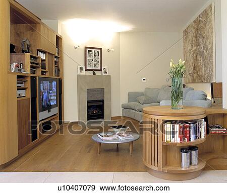 Television in built-in bookshelves in small modern living room View Large Photo Image Stock Photo - Television in built-in bookshelves in small modern living room. Fotosearch