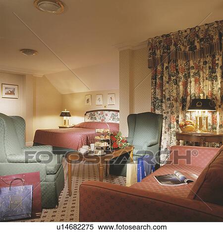 Terracotta sofa and green armchairs in hotel bedroom with floral curtains View Large Photo Image Stock Photography - Terracotta sofa and green armchairs in hotel bedroom with floral curtains. Fotosearch