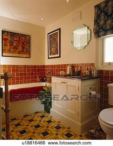 Tesselated floor tiles in bathroom with basin built in to vanity unit and red tiles above bath View Large Photo Image Stock Photograph - Tesselated floor tiles in bathroom with basin built in to vanity unit and red tiles above bath. Fotosearch