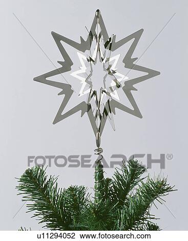 Three-dimensional cut-out silver George Jensen star on top of Christmas tree View Large Photo Image Stock Image - Three-dimensional cut-out silver George Jensen star on top of Christmas tree. Fotosearch