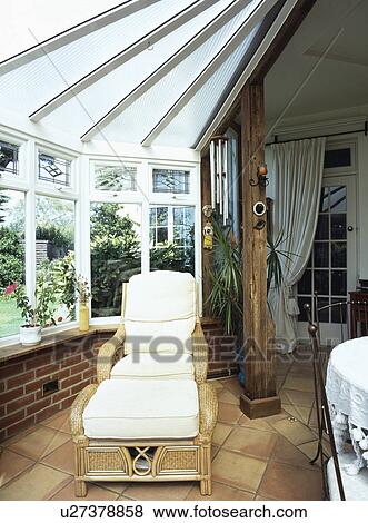 Stock Photo - Traditional conservatory living room with comfortable furniture and green plants. Fotosearch