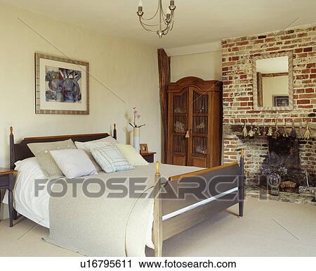 Traditional cream painted bedroom with a large bare brick fireplace View Large Photo Image Stock Image - Traditional cream painted bedroom with a large bare brick fireplace . Fotosearch