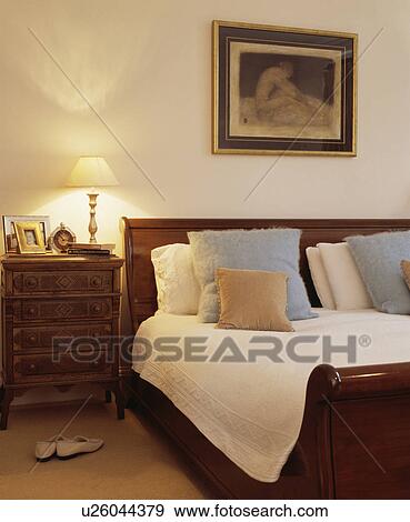 Traditional Dark Wood Bed And Bedside Table In A Large White Bedroom Stock Photo Traditional Dark Wood Bed And Bedside Table In A Large White Bedroom