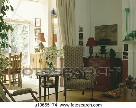 Traditional livingroom with armchair beside entrance to dining room extension View Large Photo Image Picture - Traditional livingroom with armchair beside entrance to dining room extension. Fotosearch