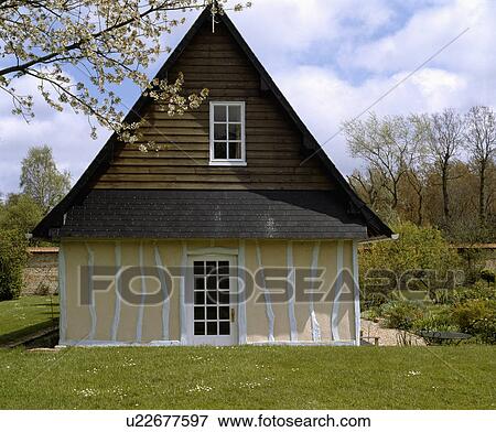 Stock Photo - Traditional white and cream timbered country cottage in France. Fotosearch