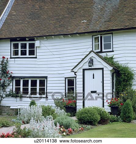 Traditional white clapboard country cottage View Large Photo Image Stock Photo - Traditional white clapboard country cottage. Fotosearch