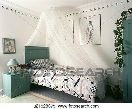 Turquoise bedside cabinet and headboard in bedroom with abstract-patterned duvet and white mosquito net above the bed View Large Photo Image Stock Photography - Turquoise bedside cabinet and headboard in bedroom with abstract-patterned duvet and white mosquito net above the bed. Fotosearch