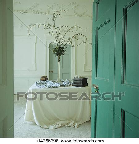 Stock Photograph - Turquoise door open to Georgian dining room with white cloth on table. Fotosearch