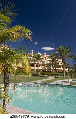 Stock Photo - Turquoise swimmingpool in front of modern apartment building in southern Spain. Fotosearch